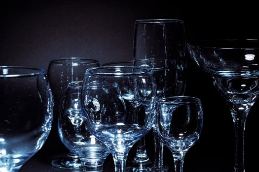 Empty glasses for drinks on dark background photo