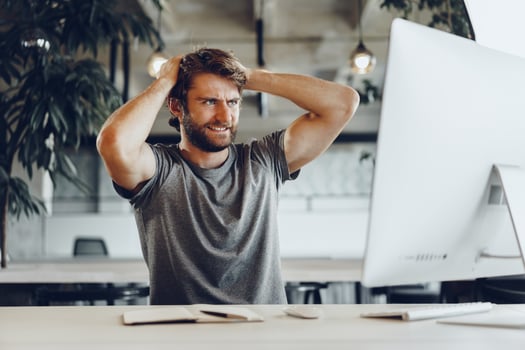 Tired businessman working on his computer in open space office photo