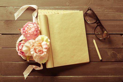 flowers and a notebook on wooden background photo