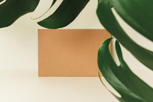 Flat lay craft paper card mockup with leaves photo