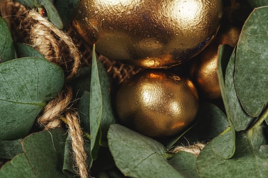 Golden colored eggs for Easter composition with floral branches photo