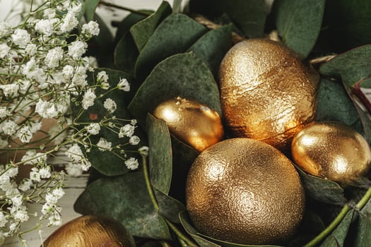 Golden colored eggs for Easter composition with floral branches photo