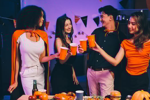 Joyful office Halloween party with coworkers in costumes, celebrating with drinks and laughter, fostering teamwork and festive spirit photo