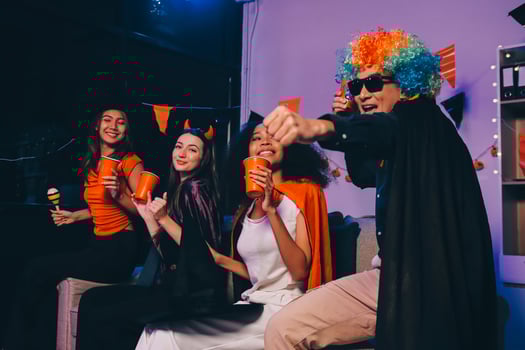 Joyful office Halloween party with coworkers in costumes, celebrating with drinks and laughter, fostering teamwork and festive spirit photo