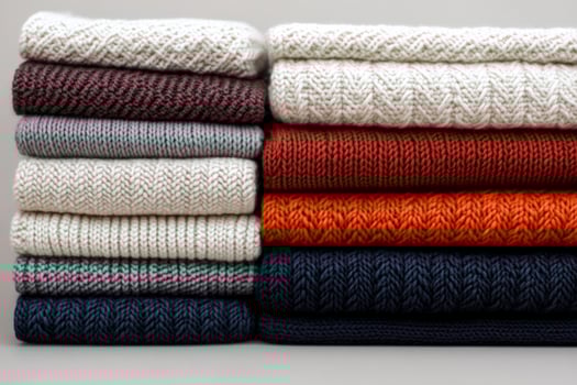 Folded wool sweaters with textured knitting patterns in various colors photo
