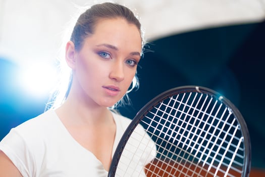 Close up portrait of a young attractive woman tennis player holding tennis racket photo