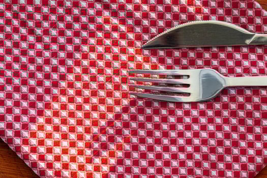 Red checkered napkin or tablecloth on wooden table photo