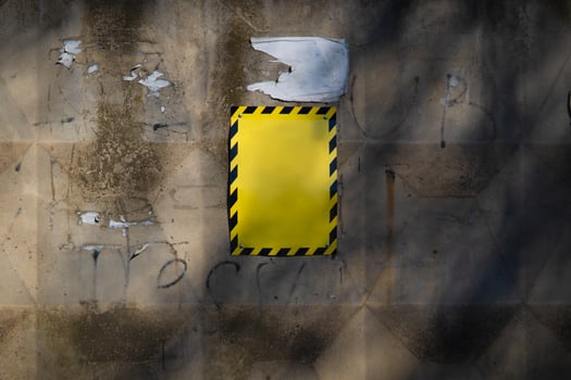 Yellow caution sign on a distressed urban wall photo