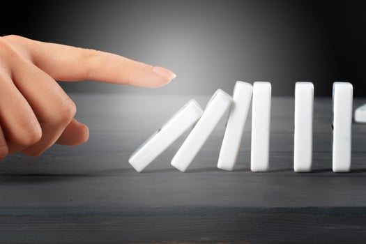 Woman hand toppling dominoes. Chain reaction business concept photo