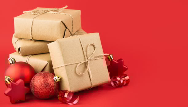 Christmas composition of gifts on a red background. Festive New Year's decorations. Christmas background. Layout of a banner, postcard. Side view. Copy space. Banner. photo