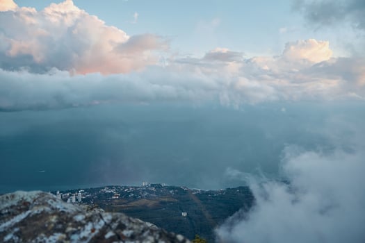 Serene Ocean View from a Majestic Mountain Summit with Fluffy Clouds in the Sky photo