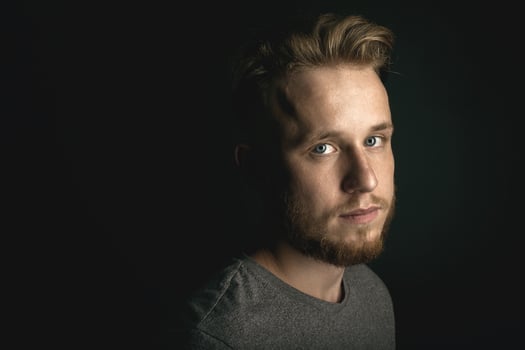 portrait of young man above black background photo