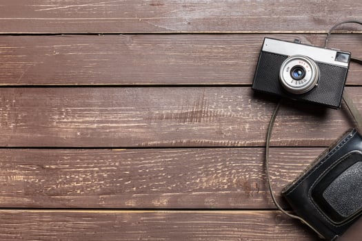 Old retro camera on wooden table background photo
