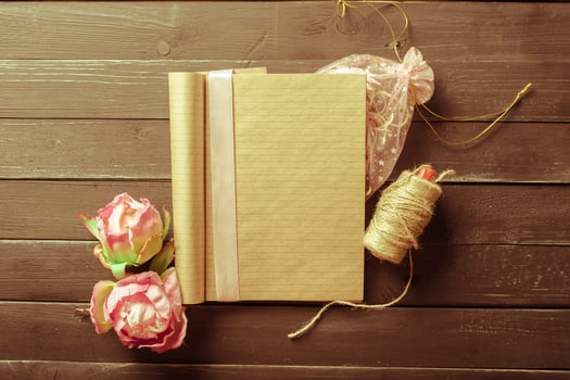 flowers and a notebook on wooden background photo