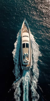 Aerial view of a luxurious yacht gliding through clear blue waters photo