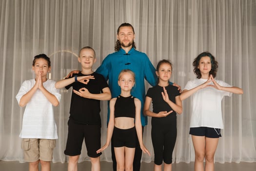A joint portrait of a yoga coach and children standing in a fitness room photo