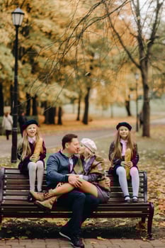 A large family is sitting on a bench in an autumn park. Happy people in the autumn park photo