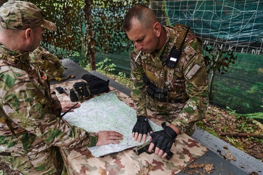 A highly trained military unit strategizes and organizes a tactical mission while studying a military map during a briefing session photo