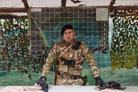 The esteemed leader of an elite military unit, strategic brilliance unfolds as he meticulously devises tactical plans for the upcoming military operation, surrounded by cutting-edge technology and a photo