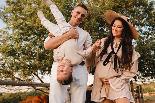 Happy family near horses at a farmer's ranch at sunset photo