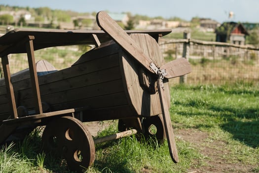 A wooden model of an airplane standing on the street in summer photo