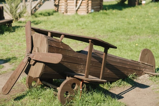 A wooden model of an airplane standing on the street in summer photo