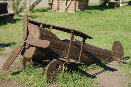 A wooden model of an airplane standing on the street in summer photo