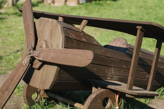 A wooden model of an airplane standing on the street in summer photo