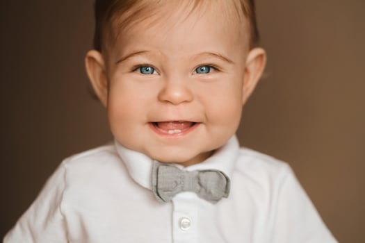 Portrait of a cheerful little boy in a white shirt with a bow tie photo