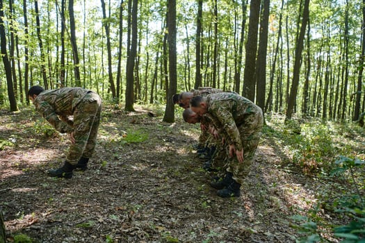 A dedicated group of soldiers engages in Islamic prayer amidst the challenging and perilous conditions of a military operation in dense forested areas photo