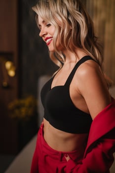 a beautiful girl dressed in a red formal suit posing in a modern interior photo