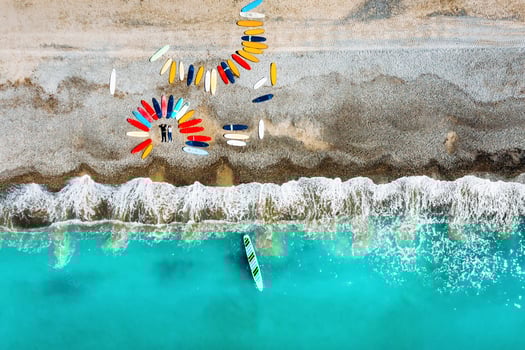 a beautiful couple is lying on the beach of France next to surfboards, shooting from a quadcopter, a lot of surfboards are unusually lying on the beach photo