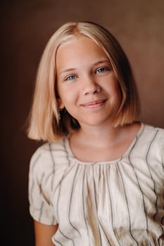 A happy child, a little girl in a gray T-shirt on a beige background photo