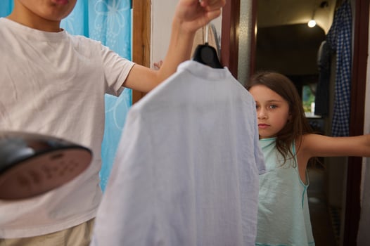 Brother and sister ironing clothes together at home photo