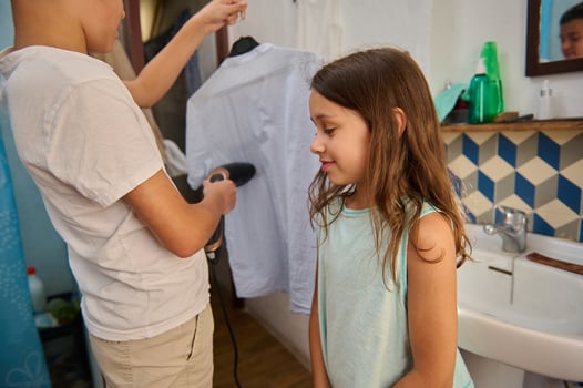 Children ironing clothes together in a cozy bathroom setting photo