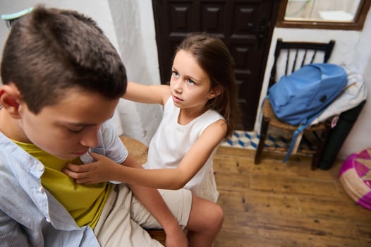 Concerned young girl checking on a sad boy indoors photo