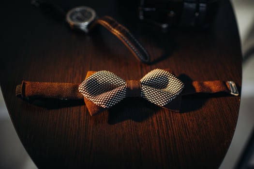 black bow tie on light background and watch photo