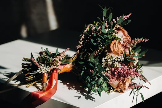 wedding bouquet with roses on the table and a boutonniere.The decor at the wedding photo