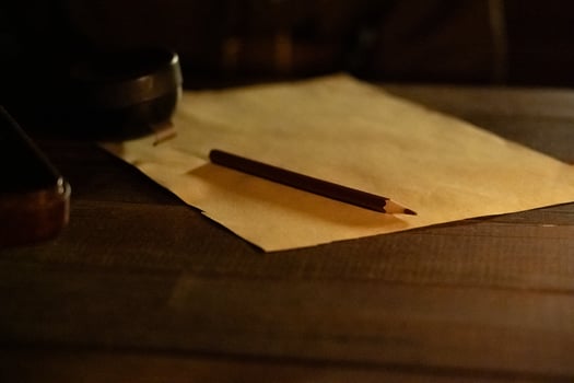 A sheet of paper with a pencil on the table in the dugout in the semi-darkness photo