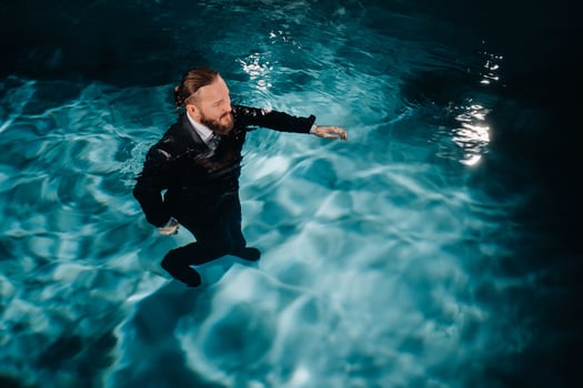 A man in a formal suit is walking in the water. A man walks on water photo
