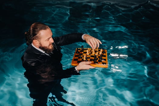 a man in a suit plays chess on the water in the pool photo