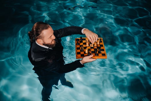a man in a suit plays chess on the water in the pool photo