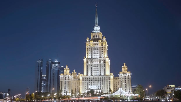 Late night cityscape with illuminated skyscraper in Moscow designed in the Stalinist style. Action. Beautiful building on a dark blue evening sky background, concept of architecture. photo