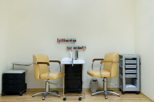 place for a manicure in a beauty salon in bright colors.Two chairs and a table in the nail care room photo