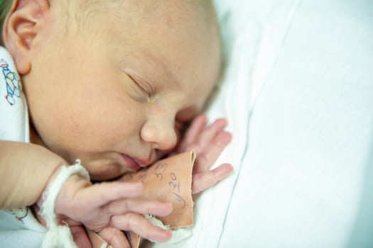 a newborn baby on the first day of its birth in the maternity hospital photo