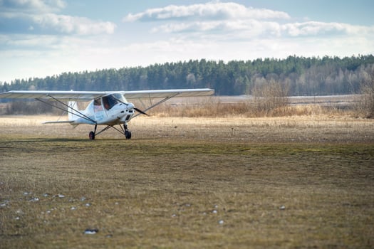 A small single-engine plane makes a landing on the ground photo