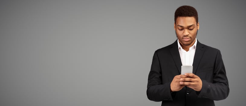 Busy Businessman. Serious afro man using phone thinking about question, white background, panorama, copyspace photo
