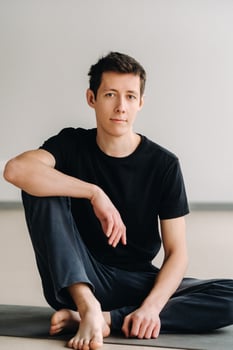 A male athlete in a black T-shirt is sitting in the gym before training and resting photo