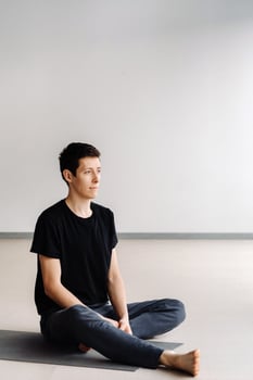 A male athlete in a black T-shirt is sitting in the gym before training and resting photo