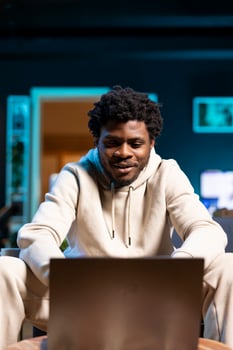 Joyous freelancing businessman working from home using laptop to send emails. Relaxed remote worker typing on notebook keyboard, delivering finalized project paperwork to management photo